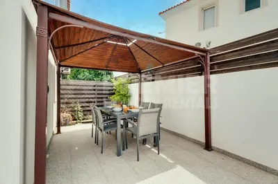 a patio with a table and chairs under an umbrella at Villa Seaview in Protaras
