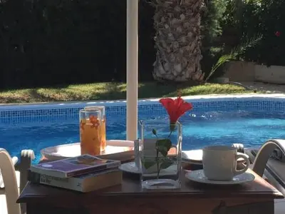 a table with a drink and a flower in a glass at Katikies 19 in Pissouri