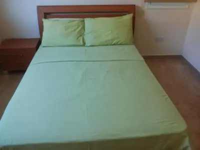 a large bed in a bedroom with a wooden headboard at Katikies 19 in Pissouri