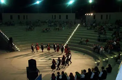 a group of people dancing in front of a crowd at Katikies 19 in Pissouri