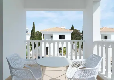 a white balcony with a table and two chairs at LuxVillasRentals Ayia Napa in Ayia Napa