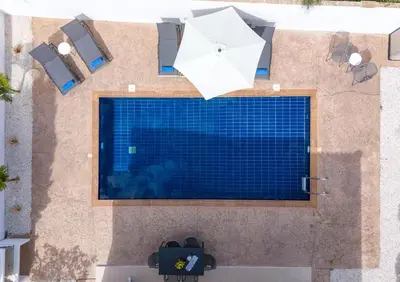 an overhead view of a swimming pool with an umbrella at LuxVillasRentals Ayia Napa in Ayia Napa