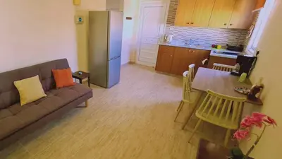 a living room with a couch and a table and a kitchen at STAY Chill n' Joy in Ayia Napa