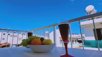 a bowl of fruit and a glass of wine on a table at STAY Chill n' Joy in Ayia Napa