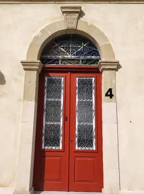 a red door on a building with the number four at St. Lazaros Studios 2 in Larnaka