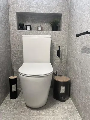 a white toilet in a bathroom with two trash cans at The Mediterranean Sea at your doorstep!! in Meneou