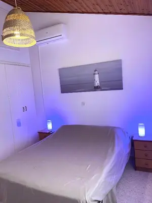 a bedroom with a bed and a lighthouse on the wall at The Mediterranean Sea at your doorstep!! in Meneou