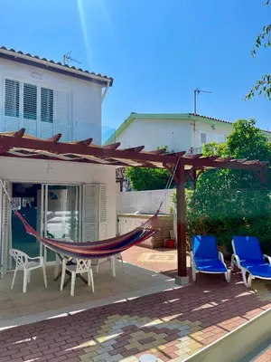 a hammock on a patio in front of a house at The Mediterranean Sea at your doorstep!! in Meneou