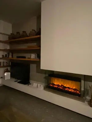 a living room with a fireplace in the wall at Luxury Villa Pluto Stunning Mountain Views in Ora