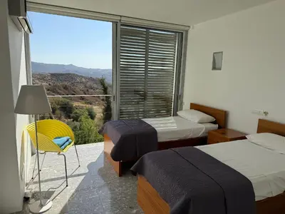 a room with two beds and a balcony with a view at Luxury Villa Pluto Stunning Mountain Views in Ora