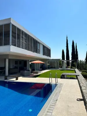 a house with a swimming pool in front of a building at Luxury Villa Pluto Stunning Mountain Views in Ora