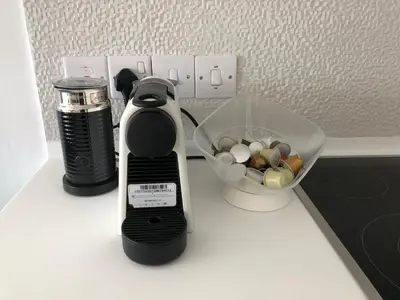 a coffee maker and a bowl of rocks on a counter at Blue Escape (Beach Seafront) in Larnaka