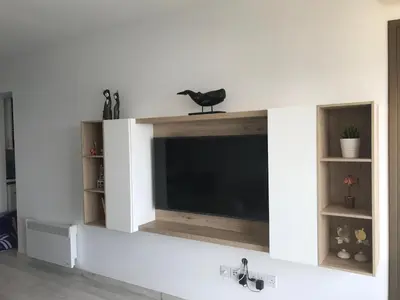 a living room with a flat screen tv on a wall at Blue Escape (Beach Seafront) in Larnaka