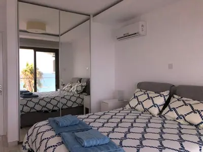 a bedroom with a bed and a mirror in it at Blue Escape (Beach Seafront) in Larnaka