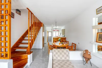 a kitchen and dining room with a staircase and a table at Maistralli Villa in Protaras