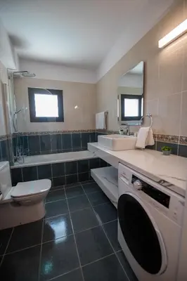 a bathroom with a sink and a toilet and a tub at Luxury Villa Agathoula in Protaras