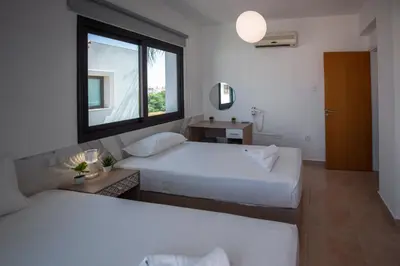 two beds in a room with a window at Luxury Villa Agathoula in Protaras