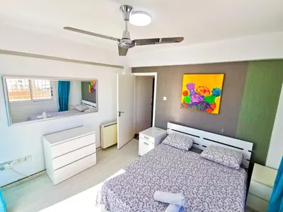 a bedroom with a bed and a ceiling fan at Sun Kissed Apartment in Larnaka