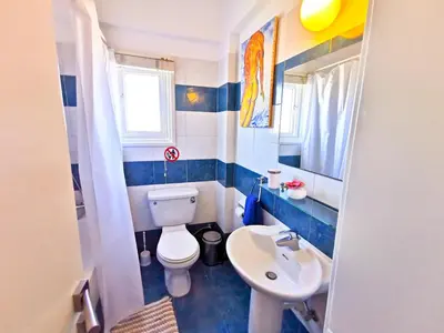 a small bathroom with a toilet and a sink at Sun Kissed Apartment in Larnaka