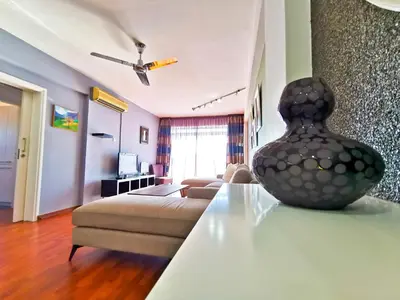a living room with a couch and a vase on a table at Sun Kissed Apartment in Larnaka