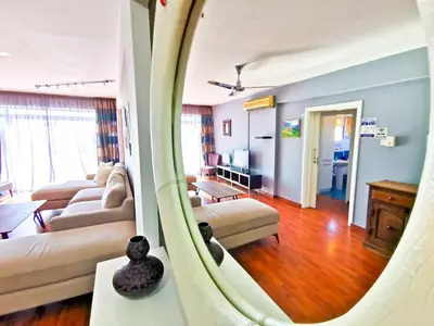 a living room with couches and a living room with a mirror at Sun Kissed Apartment in Larnaka