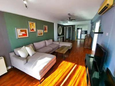 a living room with a couch and a tv at Sun Kissed Apartment in Larnaka