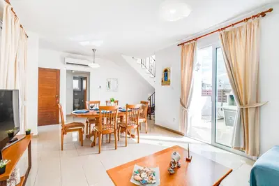 a living room with a table and a dining room at Villa Rosedale by Ezoria Villas in Ayia Napa