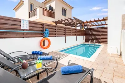 a patio with a swimming pool and a house at Villa Rosedale by Ezoria Villas in Ayia Napa