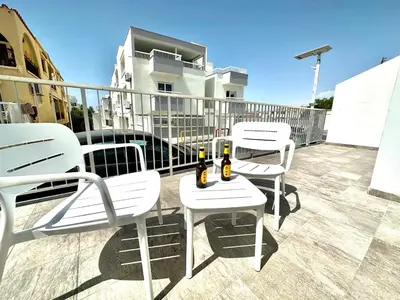 three white chairs and bottles of beer on a balcony at Serene Napa Suites - Heart of Ayia Napa in Ayia Napa