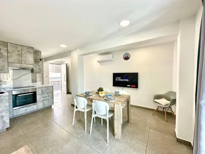 a kitchen with a table and chairs in a room at Serene Napa Suites - Heart of Ayia Napa in Ayia Napa