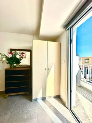 a room with a dresser and a large window at Serene Napa Suites - Heart of Ayia Napa in Ayia Napa