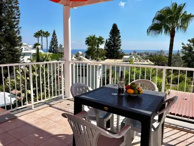 a table with a bowl of fruit on a balcony at STAY Symphony Apartment in Protaras