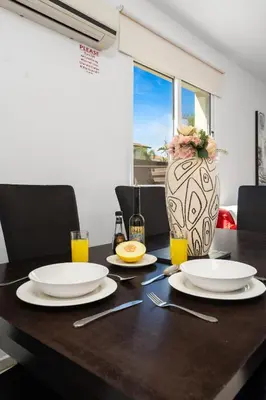 a table with plates and a vase on top of it at Villa millie Cyprus in Protaras