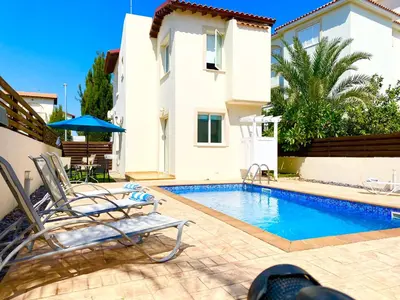 a villa with a swimming pool in front of a house at Villa millie Cyprus in Protaras