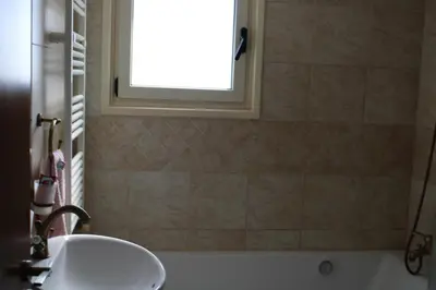 a bathroom with a sink and a window and a tub at Immaculate 3-Bed House in Pentakomo in Pendakomo