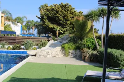 a resort yard with a pool and palm trees at Immaculate 3-Bed House in Pentakomo in Pendakomo