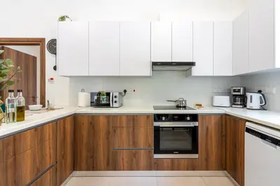 a kitchen with wooden cabinets and white appliances at Arty Haven - Spacious 3-BR House in Larnaca in Larnaka