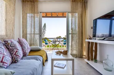 a living room with a couch and a view of the ocean at Seawaves 1- Bedroom Apartment near Meneou Beach in Larnaka