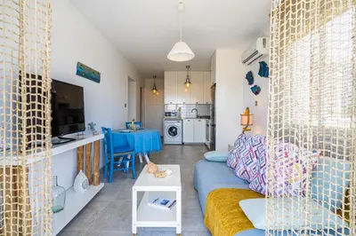 a living room with a blue couch and a table at Seawaves 1- Bedroom Apartment near Meneou Beach in Larnaka