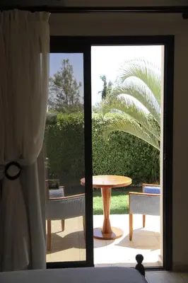 a sliding glass door leading to a patio with a table and chairs at Eve Pissouri Soultanina Villa in Pissouri