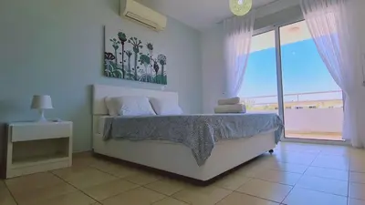 a bedroom with a bed with a view of the ocean at Nissi 3 Privileges Apt in Ayia Napa
