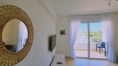 a mirror on a wall in a room with a balcony at Nissi 3 Privileges Apt in Ayia Napa