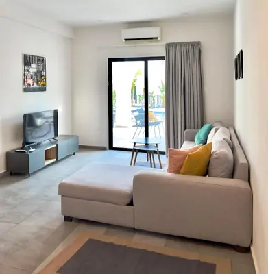 a living room with a couch and a tv at Zoi Ayia Napa in Ayia Napa