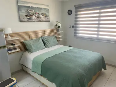 a bedroom with a large bed with a wooden headboard at Dene Hollow Ayia Napa in Ayia Napa