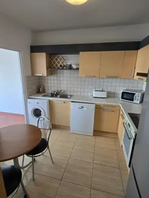 a kitchen with white appliances and a table and chairs at Carisa DownTown with Rooftop pool in Larnaka