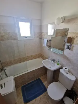 a bathroom with a toilet and a sink and a tub at Carisa DownTown with Rooftop pool in Larnaka