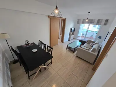 a living room with a table and a couch at Carisa DownTown with Rooftop pool in Larnaka