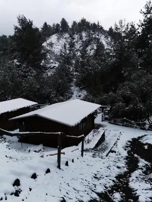 a building with snow on it in front of a mountain at Bosco Paradiso in Limassol