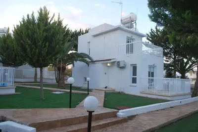 a white building with a tower on top of it at Flisvos Beach Apartments in Protaras