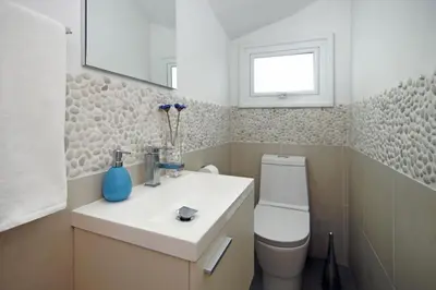 a bathroom with a sink and a toilet and a mirror at Villa Blue Oasis in Protaras